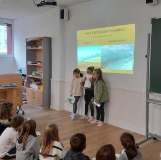 Orioko Herri Ikastolako ikasleak tsunamien inguruko azalpenak ematen.